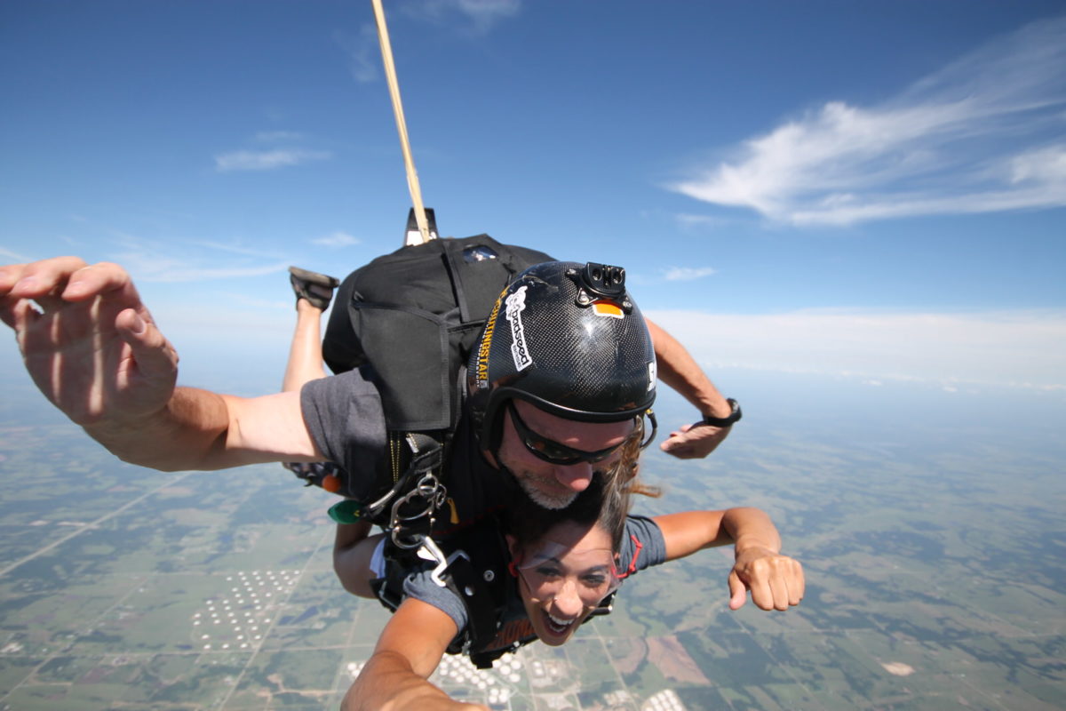 woman attached to tandem skydiving instructor