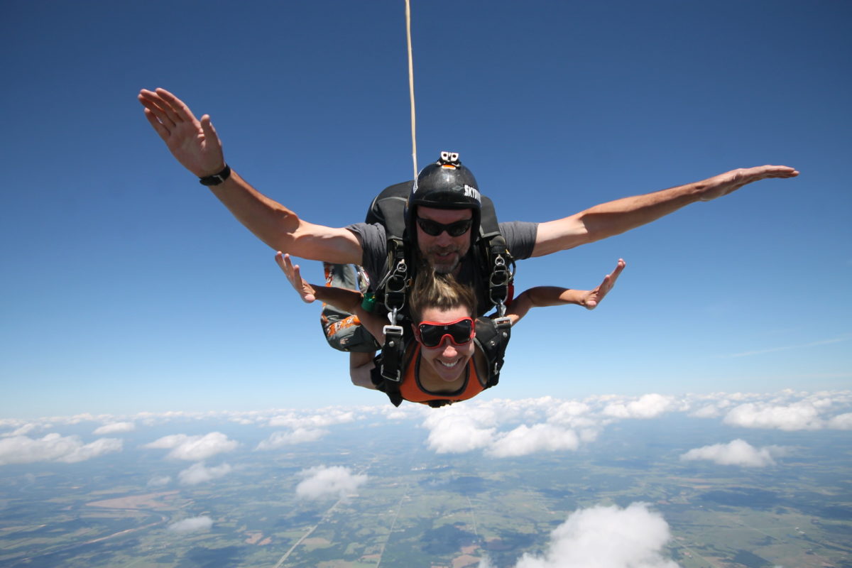 woman attached to skydiving instructor 